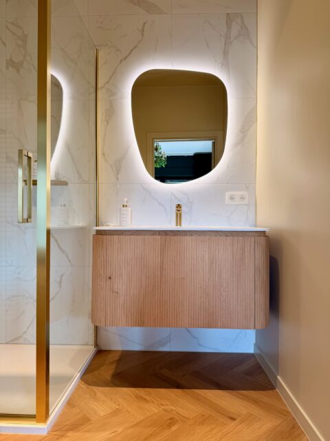 Elegant bathroom with marble finishes walk in shower and Clarins Paris soap shampoo and shower gel